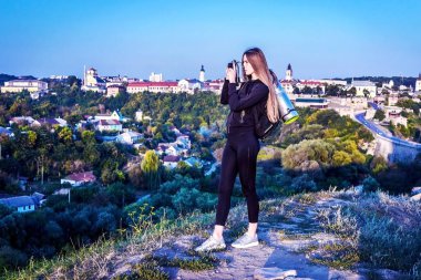 Bir güzel turist kıza, şehrin yukarısındaki yükseklik doğanın güzelliği hayran bakar.