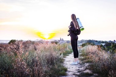 Güneş doğarken şehir manzaralı gökdelenin tepesinde duran kadın