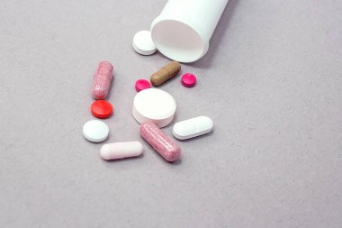 Gri bir arka plan, farklı renkler, gri bir arka plan üzerinde ilaç tablet üzerinde gri bir arka plan ile bir şişe tablet.
