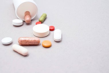 Gri bir arka plan, farklı renkler, gri bir arka plan üzerinde ilaç tablet üzerinde gri bir arka plan ile bir şişe tablet.
