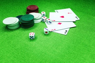 Poker fişleri dört as yeşil bir arka plan üzerinde zar.