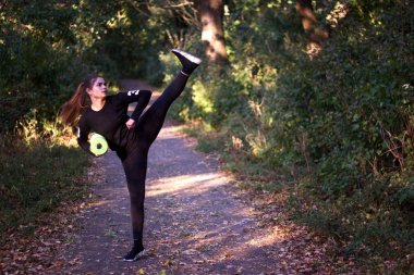 Günbatımı sırasında Parkı'nda ısınma ve germe genç kadın. Çekici kız fitness sonbahar parkta önce germe. Kışın açık fitness yapıyor güzel sportif kız.