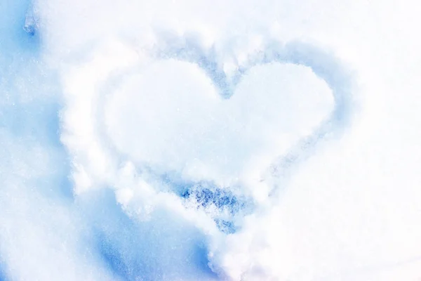 Heart drawing on the snow. We draw on the snow love.