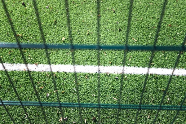 グリーン フェンス メッシュの背後にある Minifootball を再生するための芝生フィールド — ストック写真
