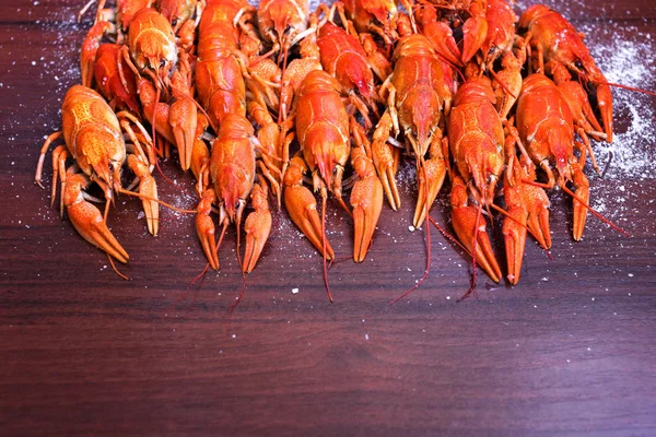 Cangrejos de río cocidos, pescado salado, pescado ahumado, patatas fritas, cacahuetes, bocadillos en platos blancos sobre una mesa de madera —  Fotos de Stock