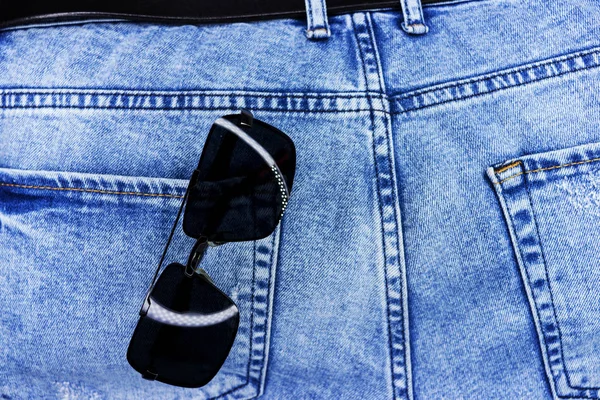 Jeans-Tasche Nahaufnahme mit Sonnenbrille. Hintergrund oder Textur. — Stockfoto