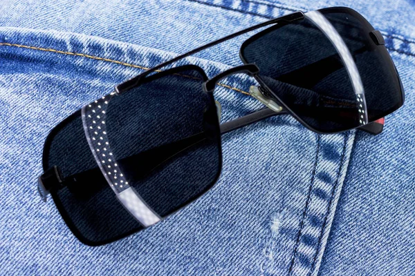 Jeans saku closeup dengan kacamata matahari. Latar belakang atau tekstur . — Stok Foto