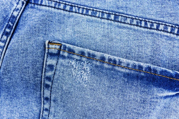 Fundo de ganga, close-up de bolsos de jeans. Calça jeans desbotada . — Fotografia de Stock