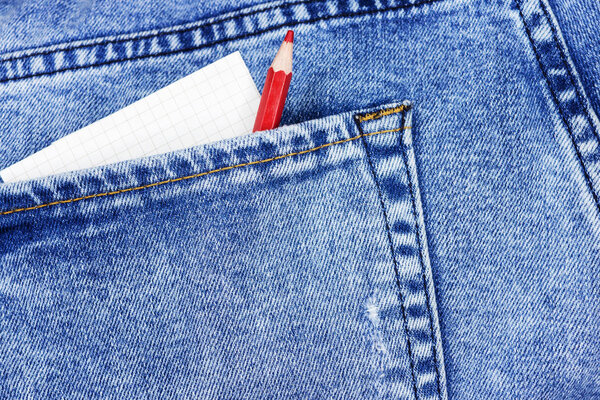 Notebook with red and green pencils in jeans pocket
