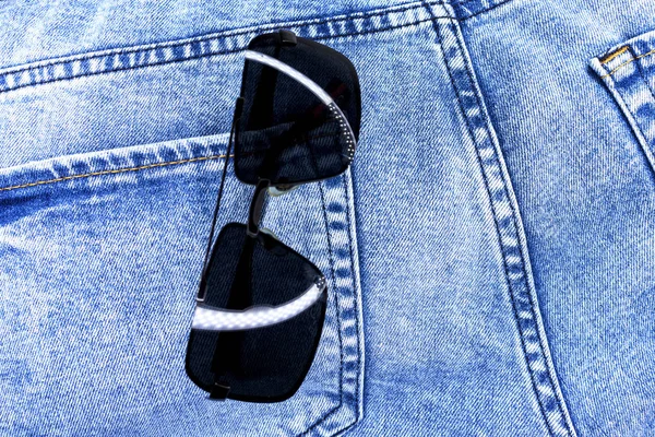 Jeans zak close-up met zonnebril. Achtergrond of textuur. — Stockfoto