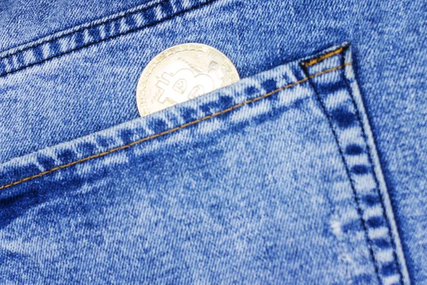 Moneda criptomoneda bitcoin en su bolsillo vaqueros. bitcoin la criptomoneda más popular en el mundo. Imagen tonificada —  Fotos de Stock