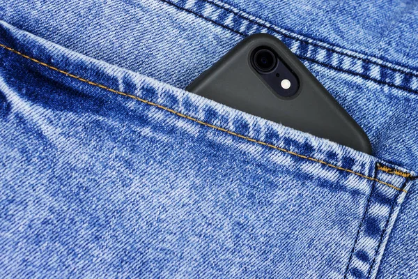 Smart phone in the back pocket of blue jeans — Stock Photo, Image