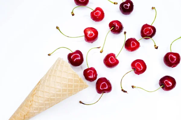 Glass kon fylld med körsbär på en ljus vit betong bakgrund. Färskt sött körsbär i våffelkon. Utsikt från ovan. Sommar koncept. — Stockfoto