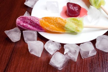 Çilek ile bir tabak üzerinde parlak popsicles