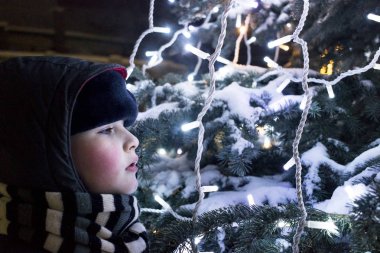 Noel ağacı, Yeni Yıl ve Noel kavramı, şenlikli ışıklar ve çelenk yanında bir kazak Çocuk. Bebeğin İlk Noel'i