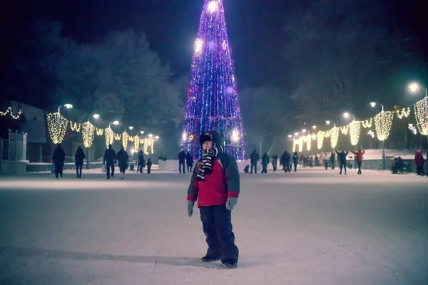 Chica de abrigo rosa en Snow Park. Chica juega en Winter Park. Adorable niño caminando en el bosque invernal de nieve. Un respiro nevado. chica cerca del árbol de Navidad y la celebración de la decoración. Nieve . — Foto de Stock