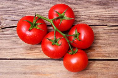 Ahşap arka planda domatesler, masada güzel bir domates dalı.