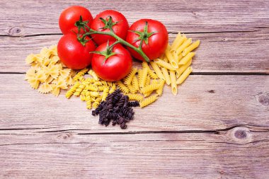 Mutfak için makarna ile arka plan. Bir demet çiğ spagetti ve bir tutam domates.