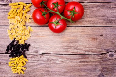 Mutfak için makarna ile arka plan. Bir demet çiğ spagetti ve bir tutam domates.