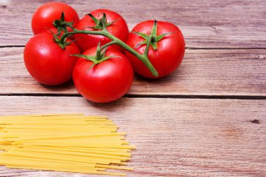 Mutfak için makarna ile arka plan. Bir demet çiğ spagetti ve bir tutam domates.