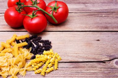 Mutfak için makarna ile arka plan. Bir demet çiğ spagetti ve bir tutam domates.