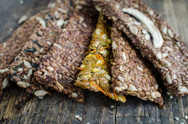 Healthy raw dessert snack. Fitness dietary food. Homemade breadsticks with flax, sunflower, pumpkin seeds on the rustic wooden board. Vegetarian nutrition concept. Copy space.