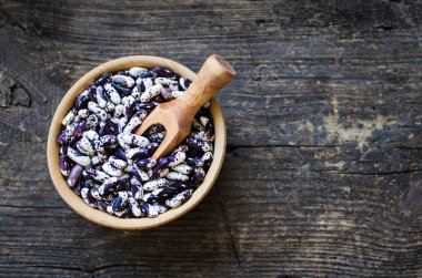 Organik mor tahıl beens rustik ahşap masa üzerinde bir kase kuru. Kuru fasulye vegan protein kaynağı. Sağlıklı gıda. Üstten Görünüm. Kopya alanı.