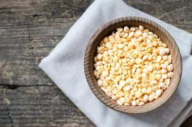 Eski ahşap zemin üzerine sarı kuru bezelye kase. Sağlıklı vegan vejetaryen gıda kavramı. Üstten görünüm.