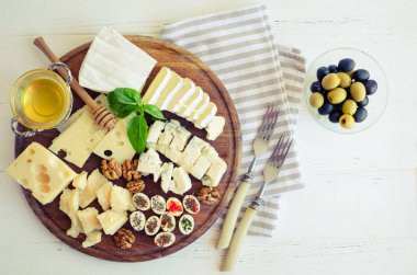 Peynir tabağı: Parmesan, kaşar peyniri, gouda, gorgonzola, brie ve diğer ceviz, zeytin ve beyaz arka plan üzerinde ahşap tahta üzerinde tatlım. Lezzetli meze peynir farklı tipteki. Üstten Görünüm.