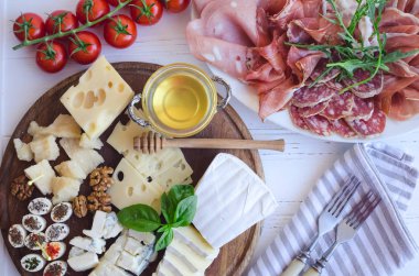 Akdeniz mezeleri, tapas ya da antipasto dolu bir masa. Çeşitli İtalyan yemek takımları. Partide ya da piknikte lezzetli atıştırmalıklar. Et ve peynirli kıyma tahtası. İtalyan usulü ziyafet. Üst görünüm.