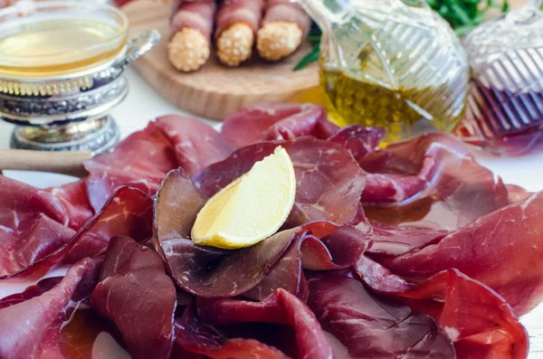 Кусочки Итальянского Мяса Bresaola Подается Оливковым Маслом Лимоном Тарелке Белом — стоковое фото