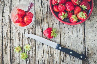 Bir bıçak ile kesme tahtası üzerinde olgun çilek.