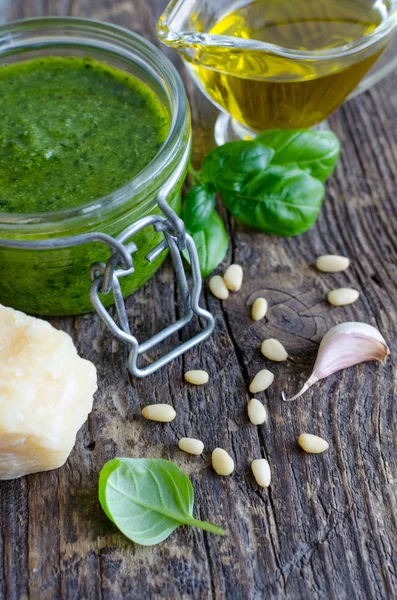 Pesto Cenova - zeytinyağı, fesleğen yaprakları, Parmesan peyniri, sarmısak ve çam fıstığı eski ahşap arka plan üzerinde geleneksel İtalyan yeşil fesleğen sos.