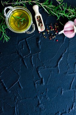 Otlar ve baharatlar seçimi - biberiye, sarımsak, limon, tuz, karabiber ve zeytinyağı karanlık taş masada. Gıda düz yatıyordu. Metin için yer ile yaratıcı düzeni. Uzay kopyalayın. Üstten Görünüm.