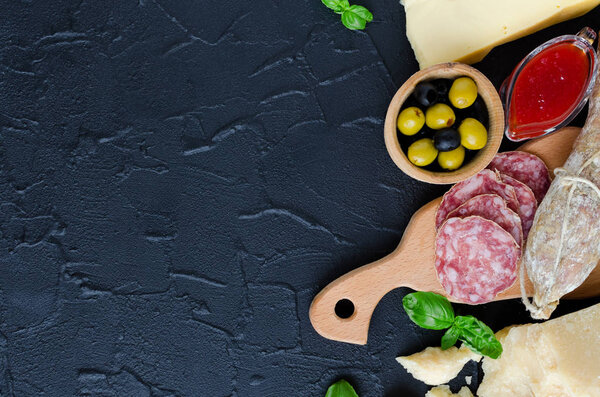 Mediterranean appetizers, tapas or antipasti. Assorted Italian traditional products food set. Delicious snack on party. Chopping board with meat and cheese. Top view. Copy space.