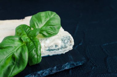 Mascarpone metin için yer ile koyu arka plan üzerinde kayrak plaka üzerinde Fesleğenli Gorgonzola peyniri. Lezzetli meze. Kopya alanı.