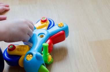 Küçük bir çocuk oyuncak motosiklet evde yerde topluyor. Çocuk parmak ustaca bir oyuncak renkli plastik parçalar ile çalışır. Çocuk oyun sırasında renkler okuyor.