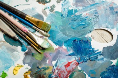 Sanatçı boya ahşap palet fırçalar. Doku farklı renklerde yağlı boya karışık. Aletleri araçları yaratıcı eğlence için. Resim hobi arka plan. Resim sanat kavramı. Üstten görünüm. Kopya alanı.