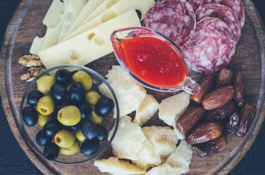 Ahşap tahta Akdeniz meze, tapas ya da meze dolu. Çeşitli İtalyan tarzı ziyafet Mama seti. Parti ya da piknik zamanında lezzetli Aperatif. Doğrama tahtası et ve peynir ile. Üstten görünüm.