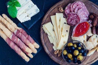 Akdeniz mezeleri, tapas ya da antipasto dolu bir masa. Çeşitli İtalyan yemek takımları. Partide ya da piknikte lezzetli atıştırmalıklar. Et ve peynirli kıyma tahtası. İtalyan usulü ziyafet. Üst görünüm.