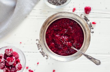 Beyaz arka plan üzerinde chia tohum ile ev yapımı frambuaz reçeli. Kahvaltı tost için sağlıklı bir fikir. Superfoods ve sağlıklı gıda kavramı. Üstten görünüm.