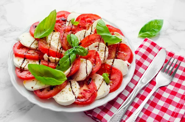 健康的な古典的な美味しいカプレーゼ完熟トマト サラダと新鮮なバジルとモッツアレラ チーズのプレートは 白い大理石の背景に残します イタリア料理のコンセプト — ストック写真