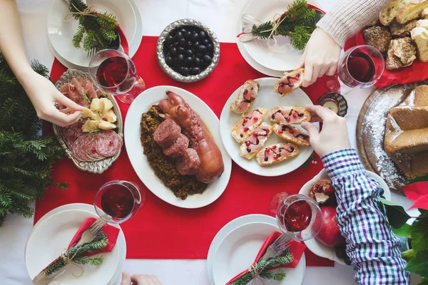Noel 'i beraber kutlayan bir grup arkadaş. Aile toplantısı konsepti. Geleneksel İtalyan Noel yemeği - Cotechino, antipasti, Panettone ve meyveli mercimek. Üst görünüm.