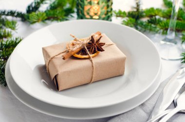 Festival Noel akşam yemeği ayarıyla tatil hediyesi. Yemek yer Çam ağaç dalları ve mum bir şekilde dekore edilmiş ve doğal dekor ile mevcut: Yıldız anason, kurutulmuş portakal dilimi ve kabuk tarçın.