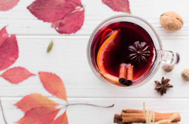 Sonbahar mulled şarap veya kırmızı şarap portakal, elma ve baharat tarçın ile temel gluhwein, Yıldız anason, küçük Hindistan cevizi, kakule ve karanfil beyaz ahşap zemin üzerinde sopa. Mevsimlik içecek tarifi. Üstten görünüm.