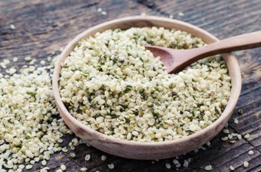 Organik beyazlatılmış kenevir tohumu rustik ahşap masa kaşık bir kase. Sağlıklı beslenme supplement. Superfood kavramı.