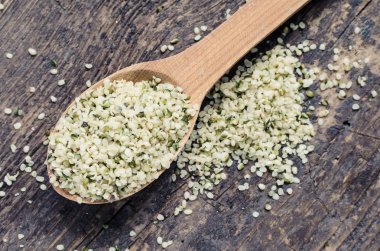 Organik beyazlatılmış kenevir tohumları bir kaşık rustik ahşap masa üzerinde. Sağlıklı beslenme supplement. Superfood kavramı.