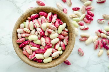 Taze organik mor tahıl-beens mermer masada ahşap kase. Kuru fasulye vegan protein kaynağı. Dengeli beslenme, yemek, vejetaryen ve temiz kavramı yeme. Sağlıklı gıda. Üstten görünüm. Düz yatıyordu.