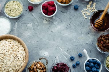 Ev yapımı granola için malzemeler: yulaf, kenevir ve kabak çekirdeği, kızılcık ve kuru üzüm, ceviz ve badem, Hindistan cevizi ve bal, taze yaban mersini ve ahududu. Superfood. Üstten görünüm. Düz yatıyordu.