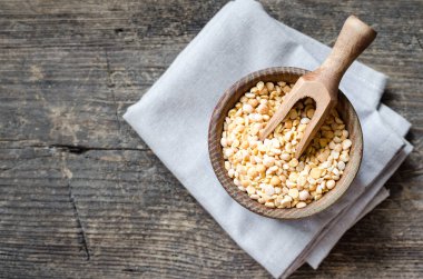 Eski ahşap zemin üzerine sarı kuru bezelye kase. Sağlıklı vegan vejetaryen gıda kavramı. Üstten görünüm. Kopya alanı.